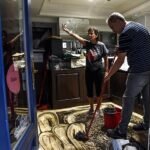 Comerciantes limpian sus locales tras la tromba de agua que anegó el Casco Viejo.